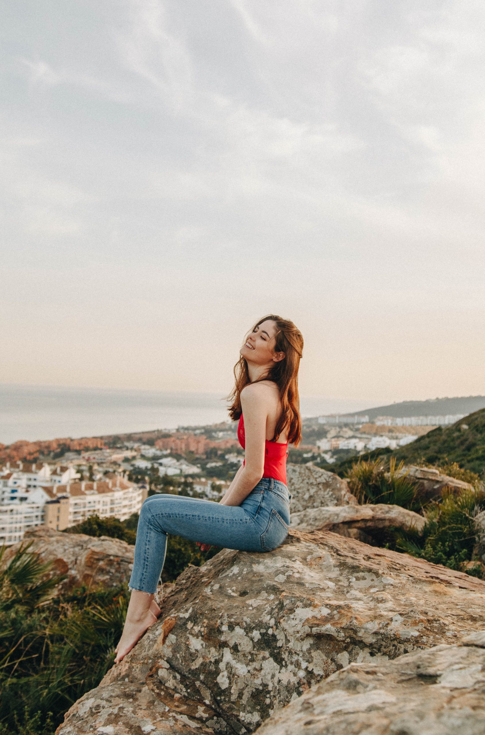Single happy woman sitting on rocks